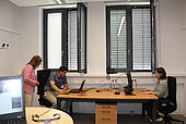 Die Doktorand*innen Celine Blettner und Marc Ritter führen Nicole Steingaß Eyetracking und Affecting Computing vor