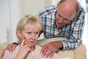 a man holds his wife, lovingly, by the shoulders.