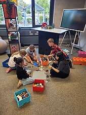 Kinderzukunftsdiplom_Lego-IBE-2026 Kinder sitzen auf dem Boden und bauen gemeinsam ein Gebäude aus Legosteinen
