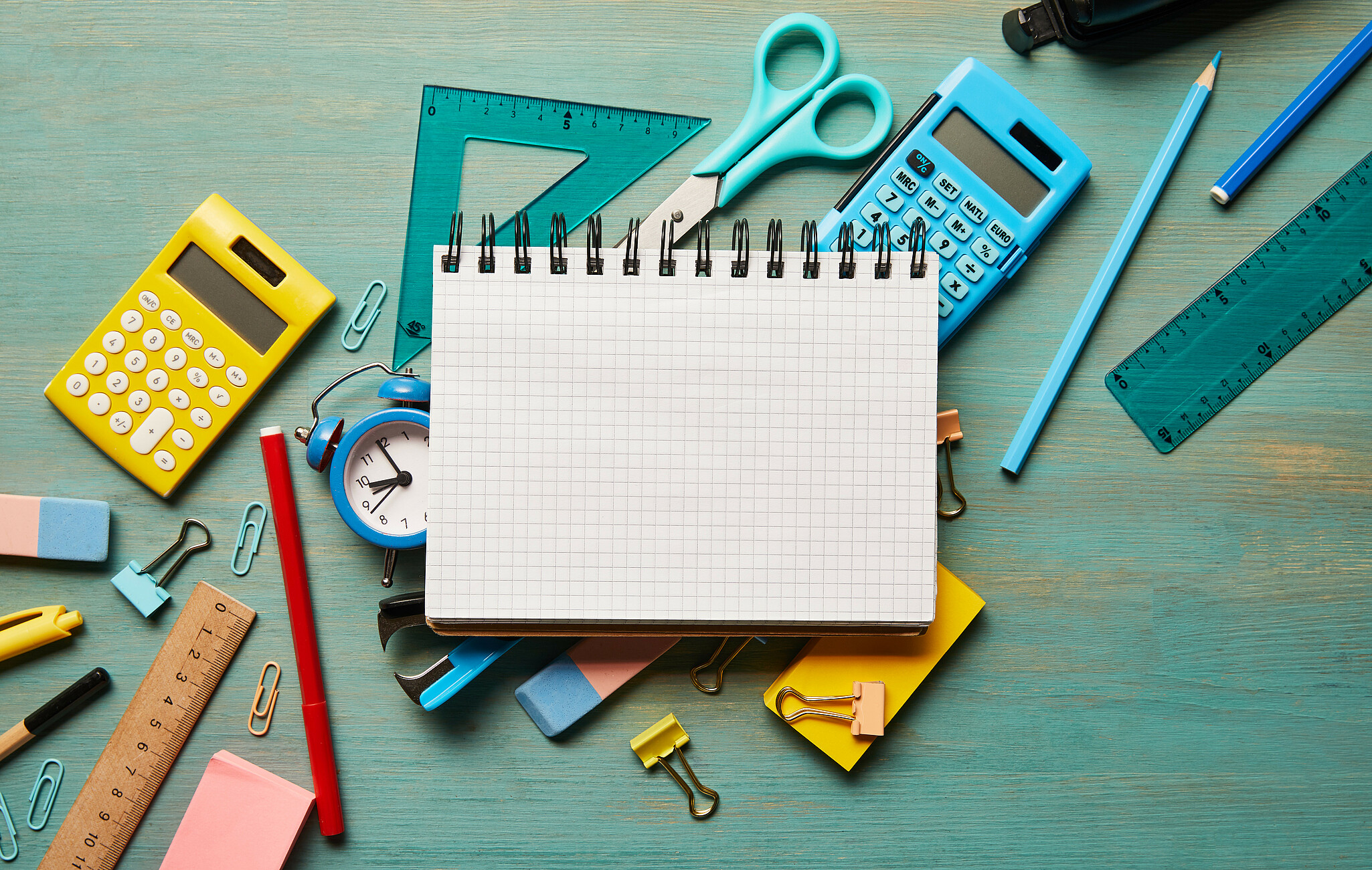 Buntes Schulmaterial vor grauem Hintergrund