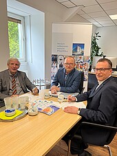 Frank Ratzlaff, Prof. Dr. Klaus Blettner und Jan Stanslowski sitzend an einem Tisch
