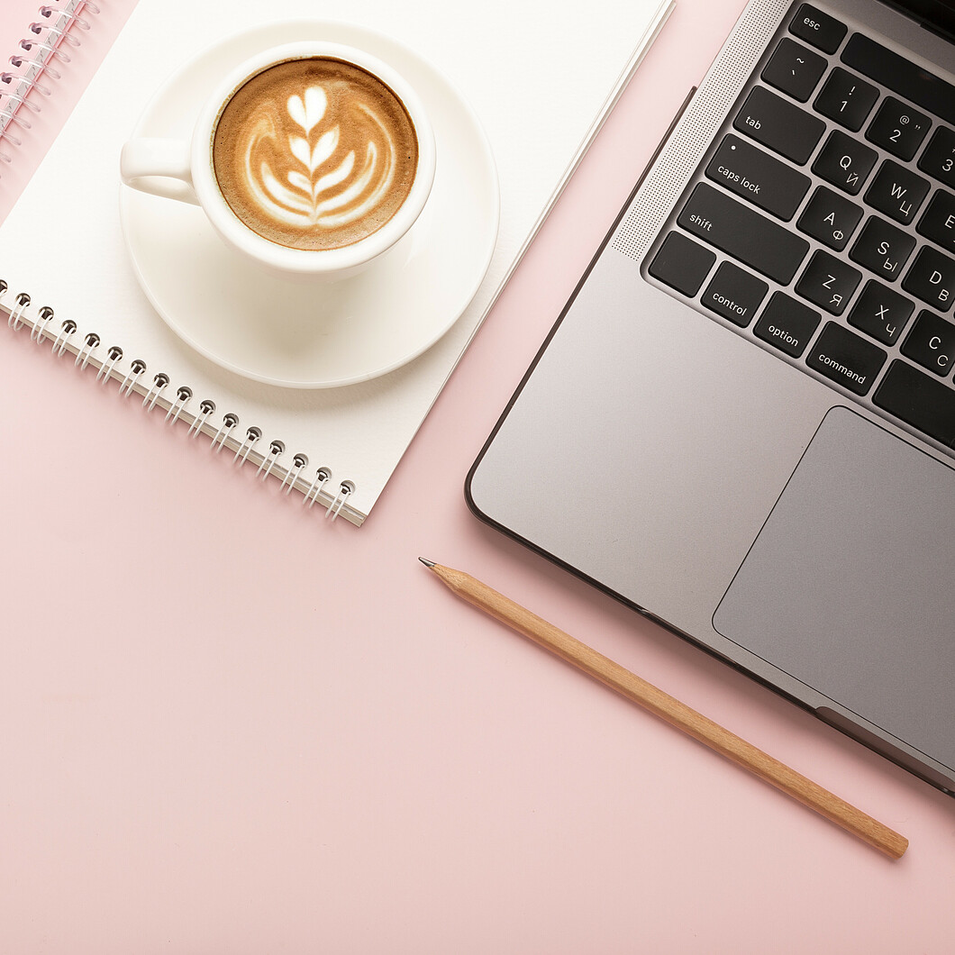 Coffee cup next to a laptop