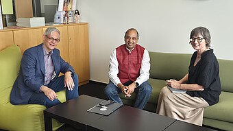 Wechsel_stellvertretende_Leitung_OAI-OAI-2026 Drei Personen sitzen in einem Büro auf Sofas und lächeln.