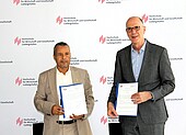 Dr. Masoud Al-Ragig, Präsident der Sebha Universität Libyen, sowie Hochschulpräsident Dr. Gunther Piller zeigen die Kooperationsvereinbarungen