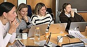 Four students in front of laptops