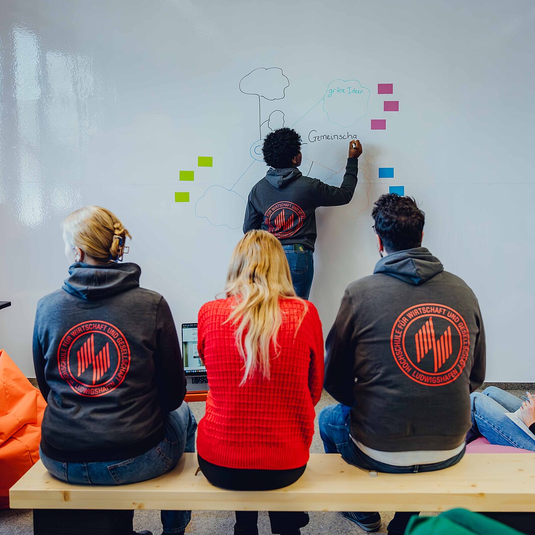 Back view of four students in front of whiteboard