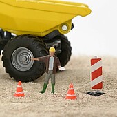 A toy construction worker with a toy wheel loader