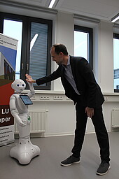 Robots and ministers high-five each other