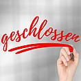 Hand schreibt "geschlossen" auf Scheibe