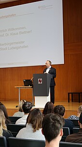 Ein Mann spricht vor Publikum auf einer Bühne in Ludwigshafen.