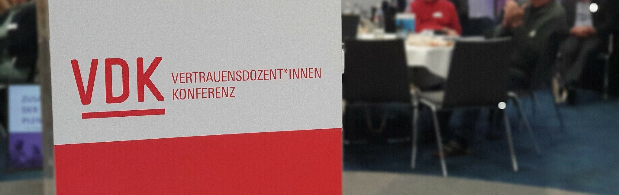 250411_Boeckler-Stiftung_Reitzig Banner der Böckler-Stiftung; im Hintergrund Konferenzteilnehmende