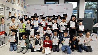 Group picture of children with graduation hats and children's future diplomas