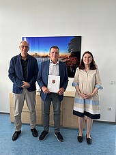 Verabschiedung_Walz-HWGLU-2026 Zwei Herren Mitte 60 und eine Frau mittleren Alters stehen lächelnd in einem Büro