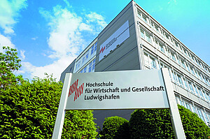 Eingangsschild der Hoschule, mit Blick auf das Hauptgebäude