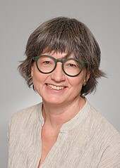Portrait of a middle-aged woman wearing glasses and sporting a pageboy cut with gray streaks
