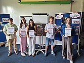 Gruppenfoto der Preisträger*innen des Fotowettbewerbs mit ihren Urkunden