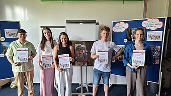 Gruppenfoto der Preisträger*innen des Fotowettbewerbs mit ihren Urkunden