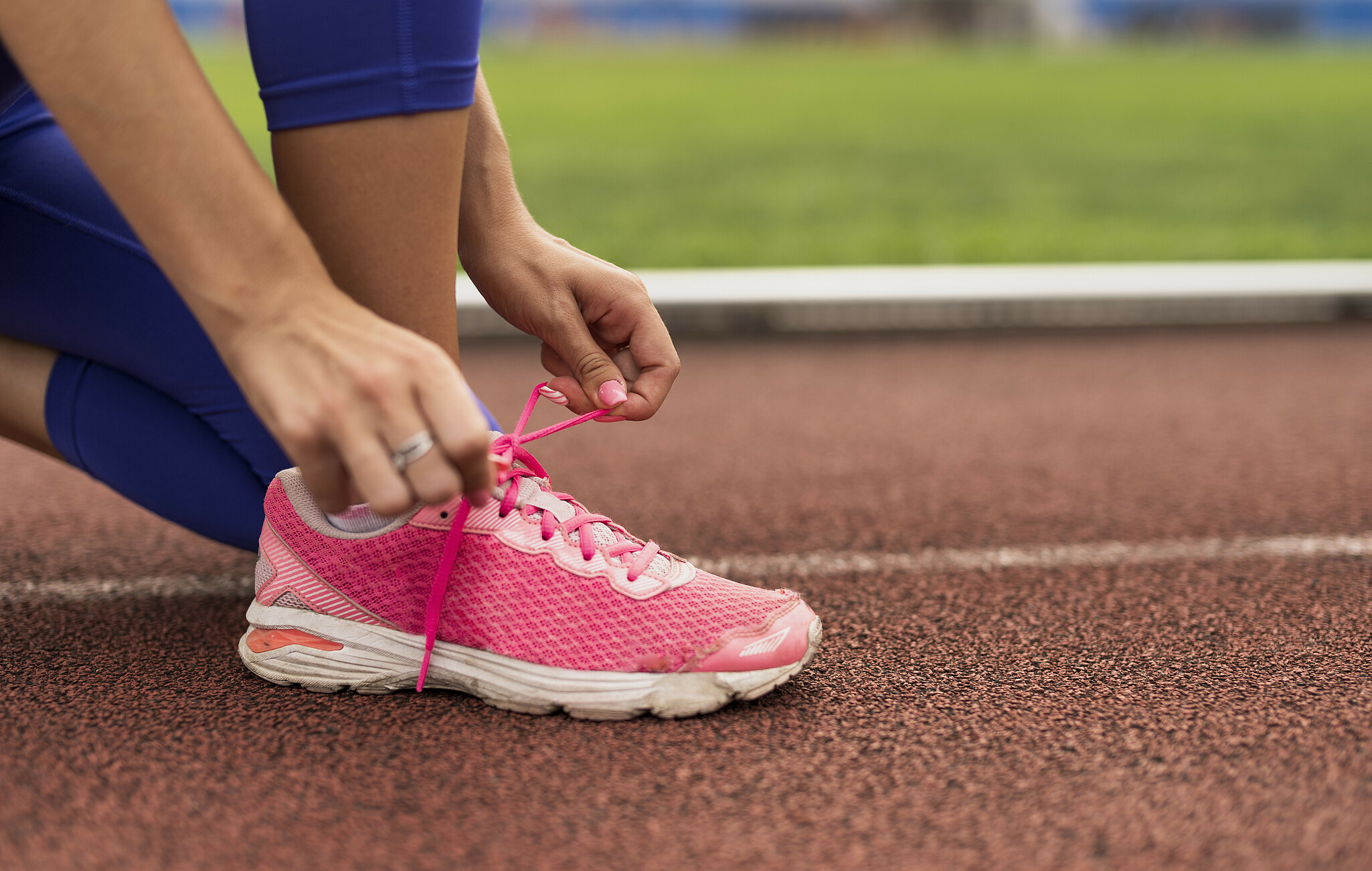Pink running shoe on running track