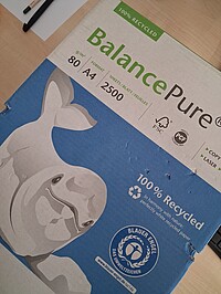 Close-up of a pack of Balance Pure printer paper, 100% recycled, A4 format, 80 g/m², 2500 sheets. The packaging features a stylized whale, the Blue Angel eco-label and recycling and FSC symbols.