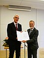 Hochschulpräsident Prof. Dr. Gunther Piller (links) überreicht die Urkunde an Ehrensenator Prof. Dr. Wolfgang Anders. (Bild: HWG LU)