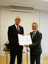 University President Prof. Dr. Gunther Piller (left) presents the certificate to Honorary Senator Prof. Dr. Wolfgang Anders. (Image: HWG LU)