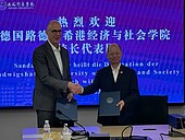 Two men shaking hands after signing the deeds
