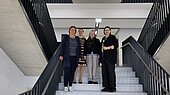 Vier Frauen mittleren Alters stehen lächelnd im Treppenhaus der Neubaus der HWG LU