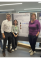 Three people stand in front of a scientific poster on research into humanoid robots and smile at the camera. The poster shows texts, diagrams and recommendations from several field studies.