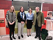 251117_Irische Pfälzer_Gruppenfoto Redner Gruppenfoto der vier Redner*innen vor der Plakatausstellung