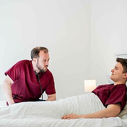 Zwei Studierende in eine Übung zum Patienten Gespräch,  einer übernimmt dabei die Rolle des Patienten.