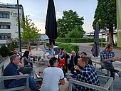 Studierendengruppe sitzt Loungemöbeln auf dem Weincampus