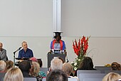 Graduate speaks at the lectern in the auditorium