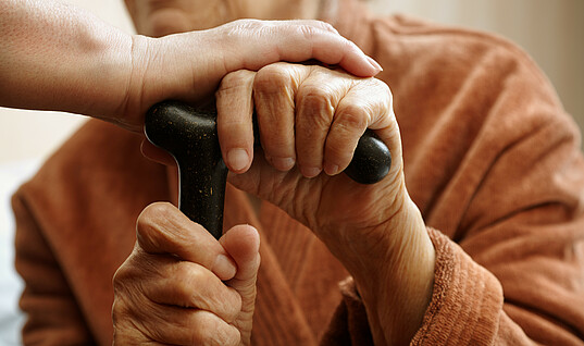 Old person with cane, gets a helping hand.