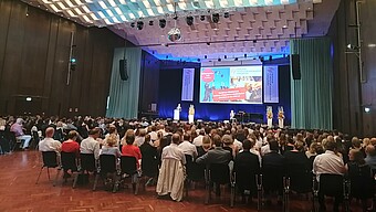 Vortrag in der Aula, mit vollen Sitzreihen