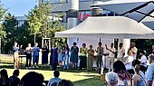 HWG_Voices_Charity_Konzert-HWG LU-2026 Chor singt unter einem Baldachinzelt auf der Wiese vor der Mensa, im Vordergrund sitzende Zuschauer*innen