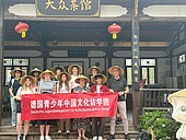 Group photo of the youth delegation with Asian hats in front of the temple