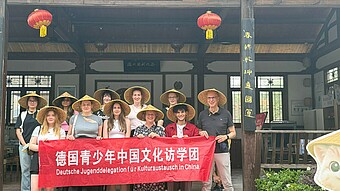 Gruppenbild der Jugenddelegation mit asiatischen Hüten vor Tempel