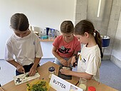 Three children making butter